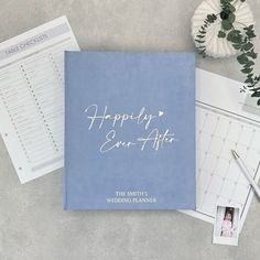 a blue wedding planner with the words happily ever after written on it next to a calendar