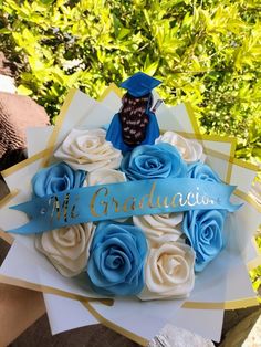 a graduation cake with blue and white roses