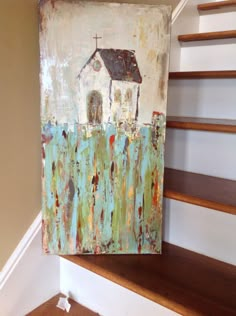 a painting is hanging on the wall next to some stairs and a stair case with a church painted on it