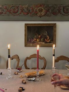 a person sitting at a table with food and wine glasses in front of them,