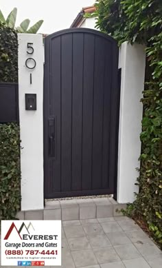 a black and white gate with the number 50 on it in front of a house