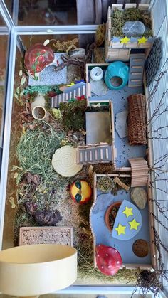 an indoor play area with toys and other items in the house, including a bird cage