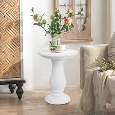 a white table with flowers on it in a living room