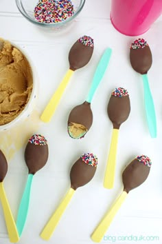 chocolate covered spoons with sprinkles next to a bowl of ice cream