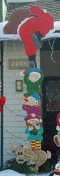 christmas decorations are hanging from the roof of a house in front of a fire hydrant