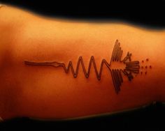 a tattoo on the arm with sound waves