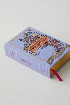 an open book with a red ribbon on the front and back cover, sitting on a white surface