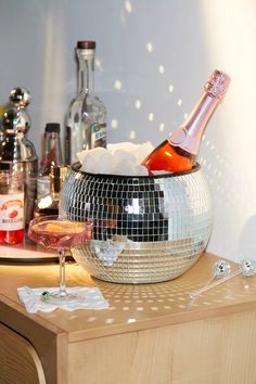 a disco ball is sitting on a table next to a wine glass and bottle in it