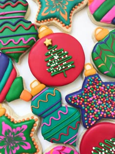 decorated christmas cookies arranged on top of each other in different shapes and colors with decorations