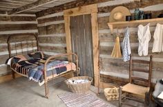 an old fashioned bedroom with wooden walls and flooring