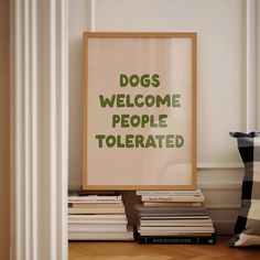 there is a sign that says dogs welcome people tolerrated on the wall next to books