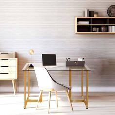 a desk with a laptop on it in front of a book shelf