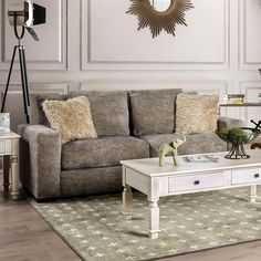 a living room with a couch, coffee table and lamp on the side tables in front of it