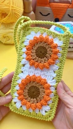 someone is holding up a crocheted phone case