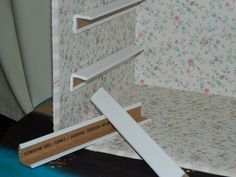 an open cardboard box sitting on top of a table next to a wallpapered wall