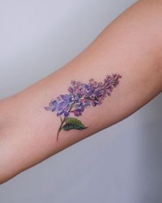 a woman's arm with purple flowers on it