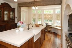 a large kitchen with wooden cabinets and white counter tops, along with a center island