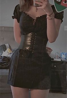 a woman taking a selfie with her cell phone wearing a corset and stockings