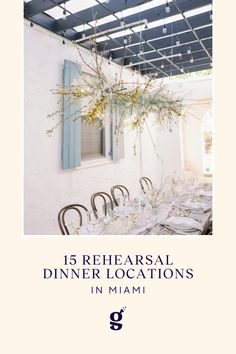 an image of a dining room table with chairs and flowers hanging from it's ceiling