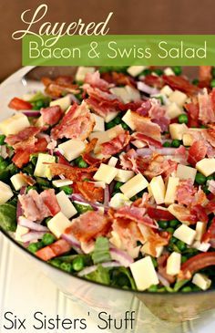 a salad with bacon, cheese and peas in a bowl