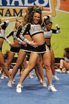 a group of cheerleaders performing in front of a crowd with a caption