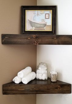 a bathroom shelf with towels on it and a framed picture above the shelf, along with other items