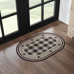 a black and white checkered rug on the floor in front of a glass door