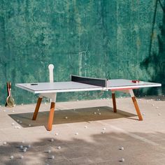 a ping pong table sitting in front of a green wall with the words more colors on it