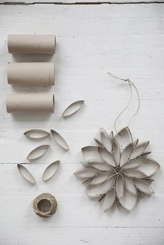 some toilet paper rolls and other items on a white wooden surface with one rolled up in the shape of a flower