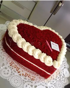 a heart shaped red velvet cake with white frosting