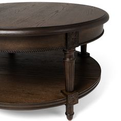 an oval coffee table with two wooden legs and a round shelf on one side that holds a tray for storing items