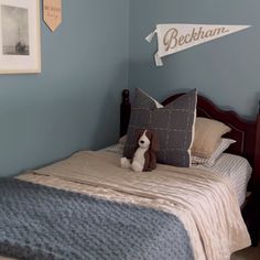 a bedroom with a bed and pictures on the wall, including a teddy bear sitting on top of it