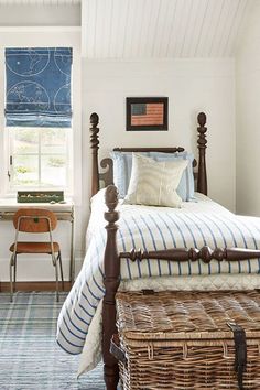 a bed sitting in a bedroom next to a window with blue and white decor on it