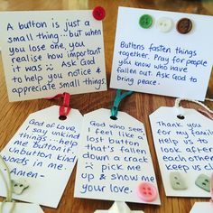 four pieces of paper with words and buttons attached to them on a wooden table top