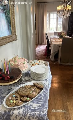 a table topped with cookies and cakes next to a cake on top of a plate