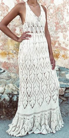 a woman in a white crochet dress standing with her hands on her hips