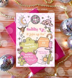 a pink and gold birthday party card with disco balls on the table next to it