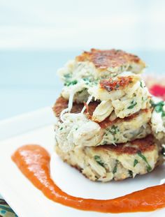 crab cakes with sauce on a white plate