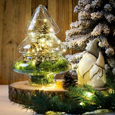 a christmas tree with lights in the shape of an ornament next to a pine cone