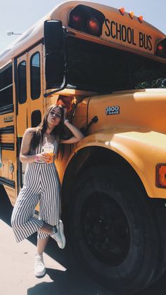 a woman leaning against the side of a school bus