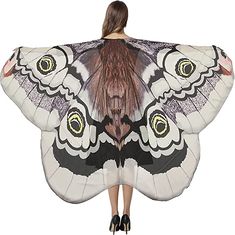 a woman is holding a large butterfly shaped shawl