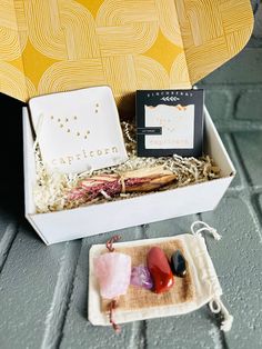 an open box containing soaps, rocks and other items on a wooden table top