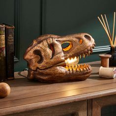 a dinosaur head is sitting on a table next to some books and other items,