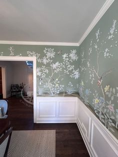 an empty room with painted flowers on the wall and wood flooring in front of it