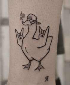 a tattoo on the leg of a person with a ducky bird in it's hand