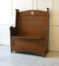 an old wooden bench sitting in front of a white wall