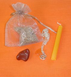 an orange table with two rocks, a candle and some other items on the table