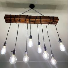 a chandelier made out of wooden planks with light bulbs hanging from it