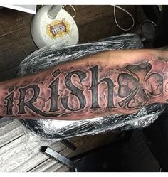 a man's arm with the word irish on it and an image of a bear