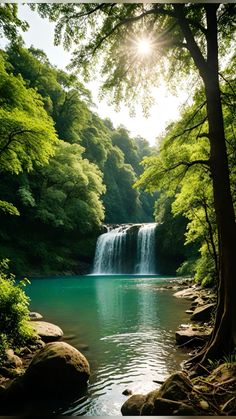 the sun shines brightly over a waterfall and some trees in the foreground, as it is surrounded by green foliage